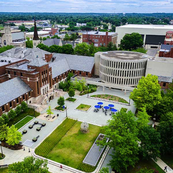 Aerial shot of campus in summertime, with Parsons Hall and Tirey Hall visible, along with part of the quad. Many other buildings are visible in the background.
