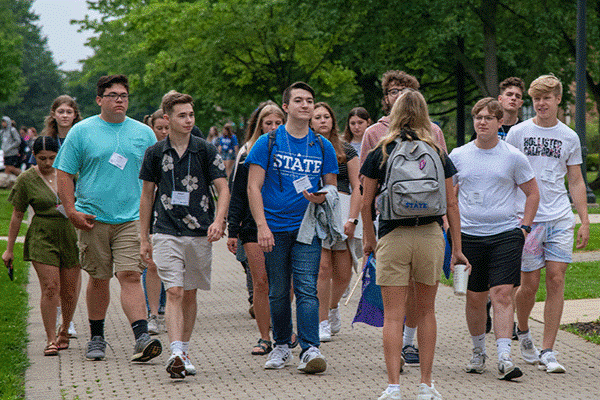 A group of students walking down a pathway on campus during a group tour