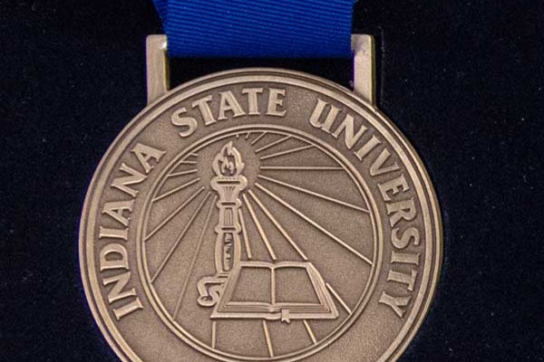 University medal with a blue lanyard bearing the Indiana State seal.