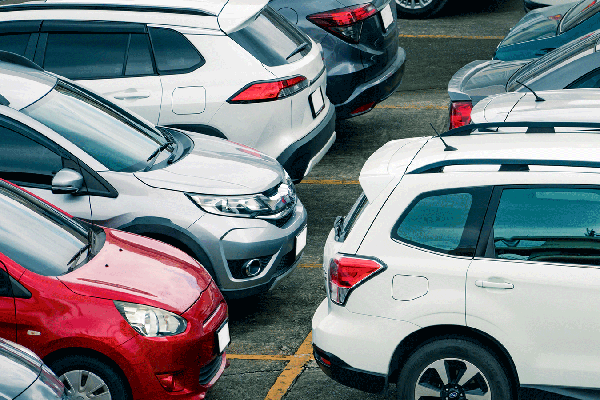 Image of several cars of varying colors parked in a row
