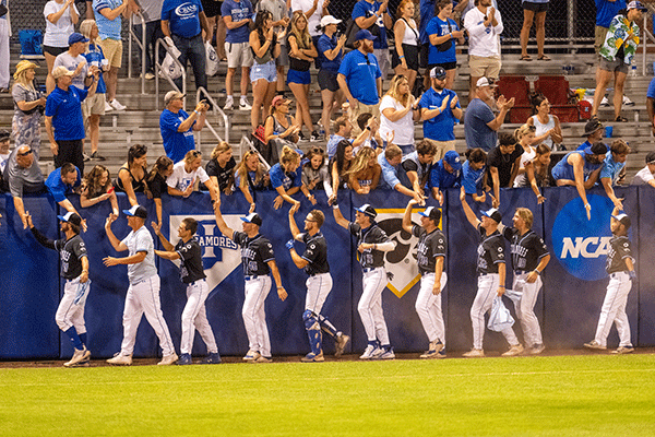 ISU baseball players give high-fives to crowd in the stadium during a game