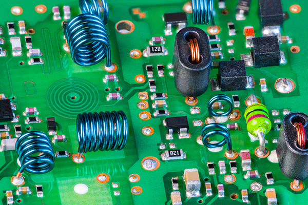 Detailed image of a green circuit board with a variety of colorful components and connections on the board. 