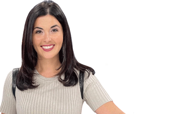 A woman with shoulder-length black hair and wearing a beige, textured, short-sleeved sweater smiles broadly at the camera. She is pictured with a white background.