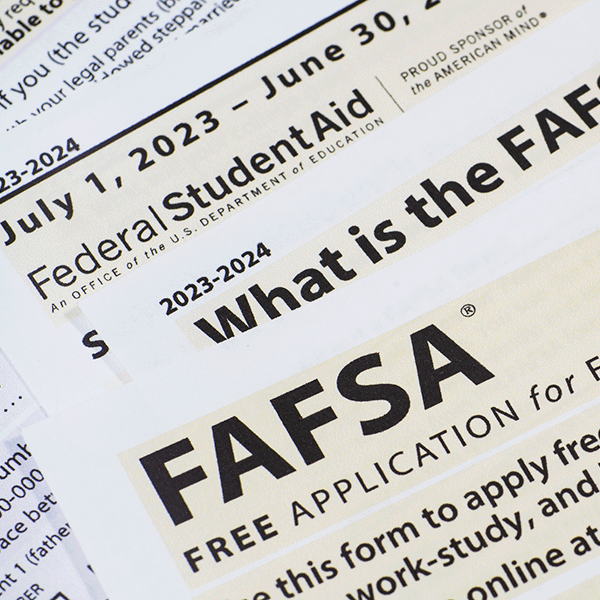 Close-up of printed documents related to the FAFSA (Free Application for Federal Student Aid) for the 2023-2024 academic year. The text highlights key phrases such as 'What is the FAFSA,' 'Federal Student Aid,' and application dates from July 1, 2023, to June 30, 2024.