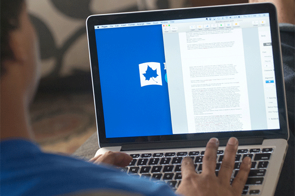 An over the shoulder image of a black male student using a laptop, with an Indiana State University page showing on the screen