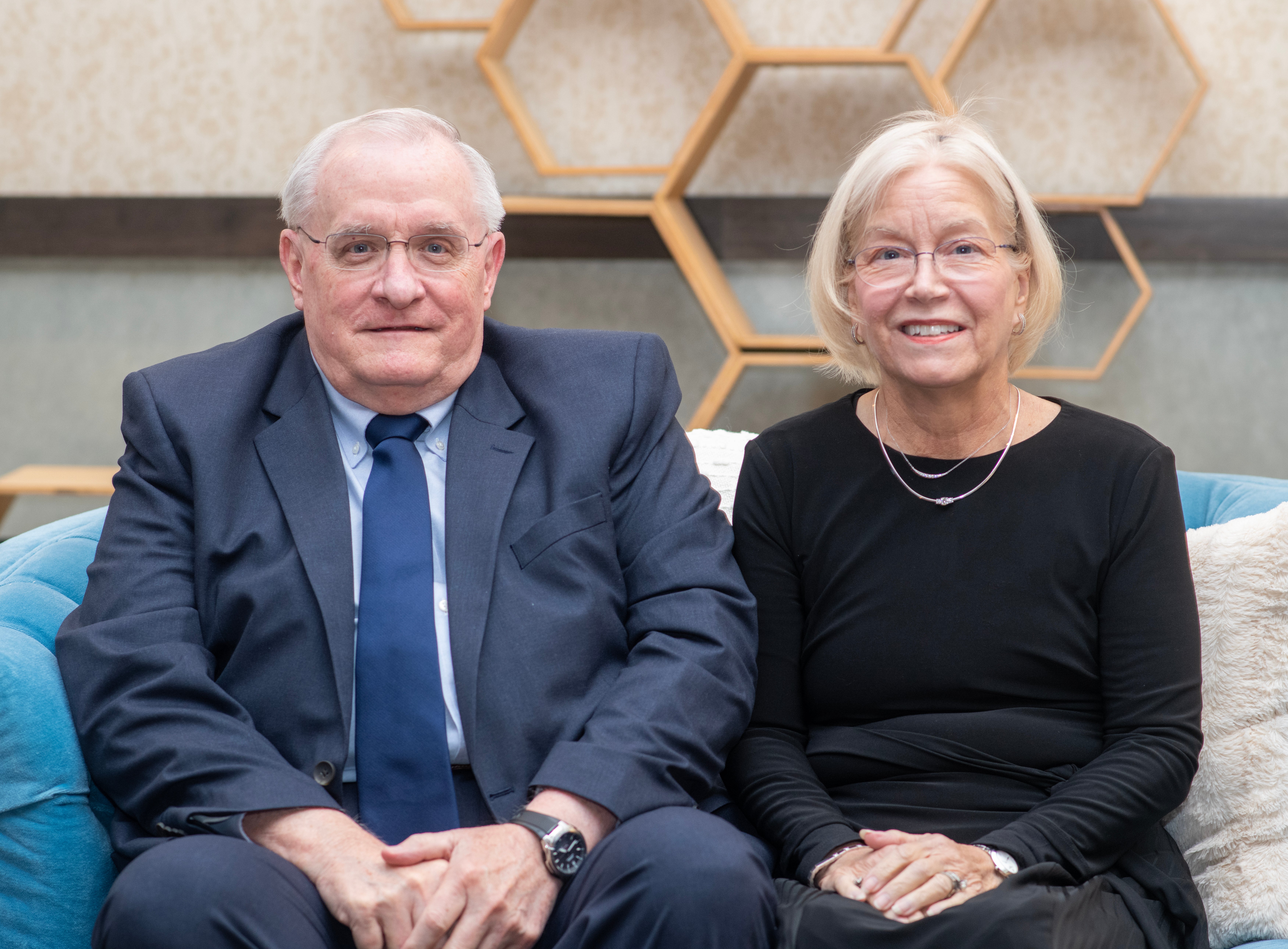 Jerry Cockrell (left) and Jan Cockrell (right) sit side by side on a sofa. 