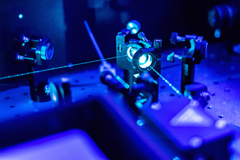 Physics optical lab equipment with light sources in a blue-tinted photo.