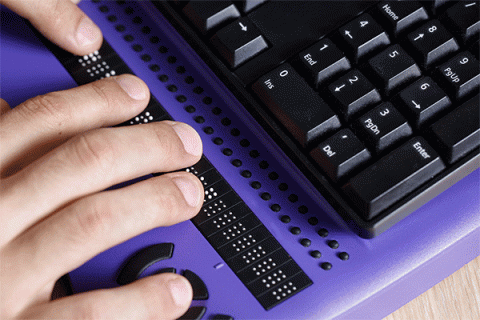 Fingers typing on a braille keyboard