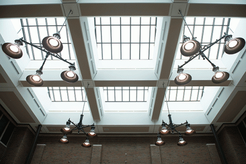Large circular lamps and large windows that make up the ceiling in the atrium of the Bayh College of Education.