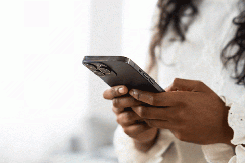 – DETAIL OF AN AFRICAN AMERICAN FEMALE HOLDING A DIGITAL PHONE. 