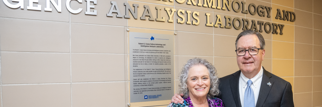 Trustee Casey in front of signage